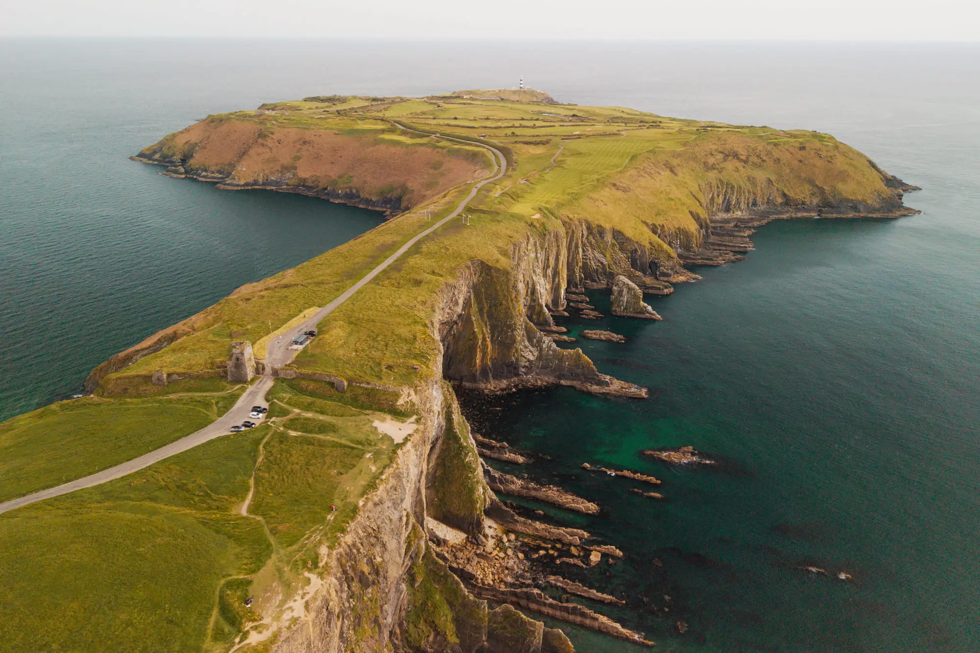 The Old Head of Kinsale reaching out to sea, a single road along its spine