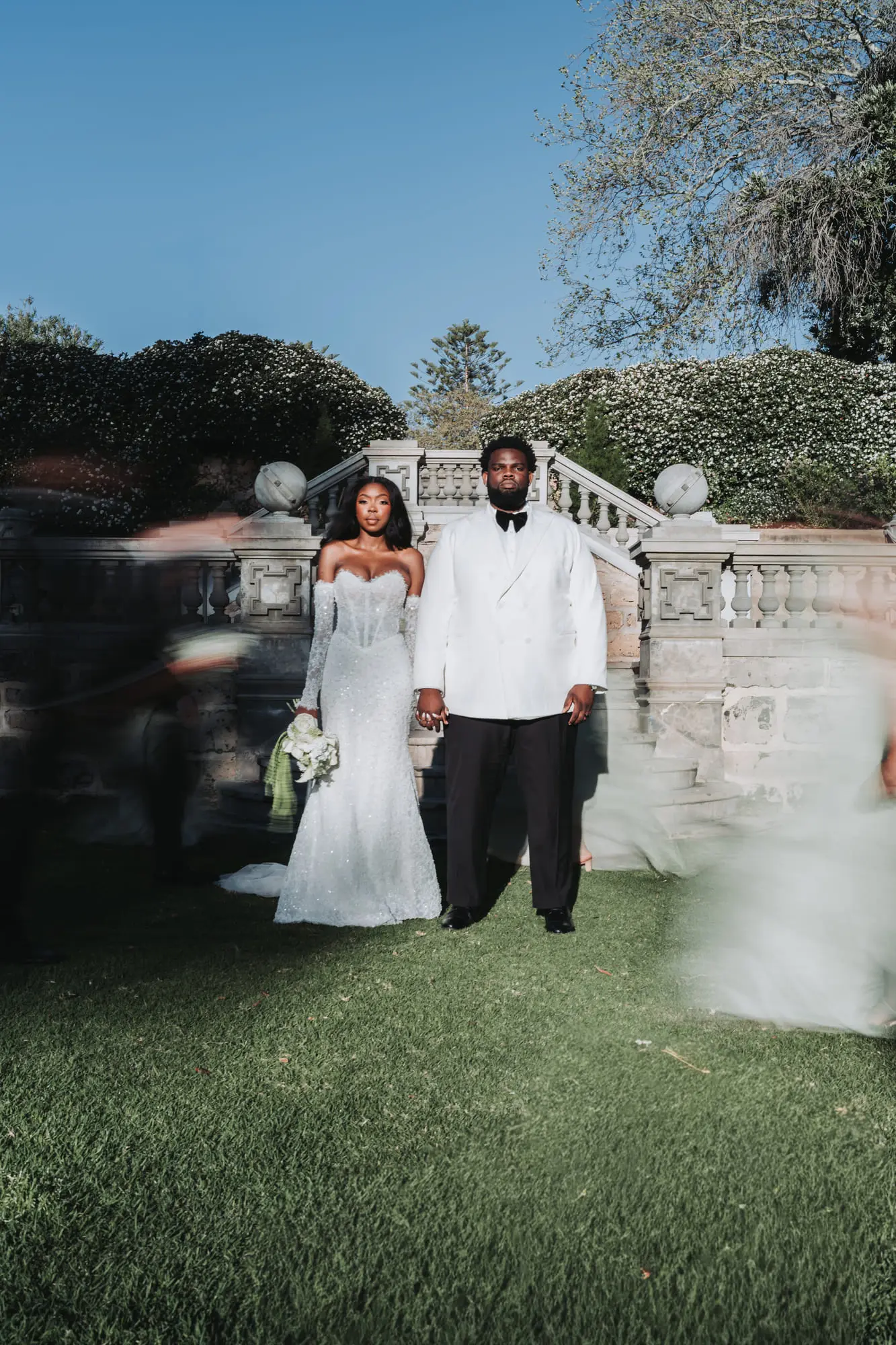 Newlyweds standing still as their guests blur past