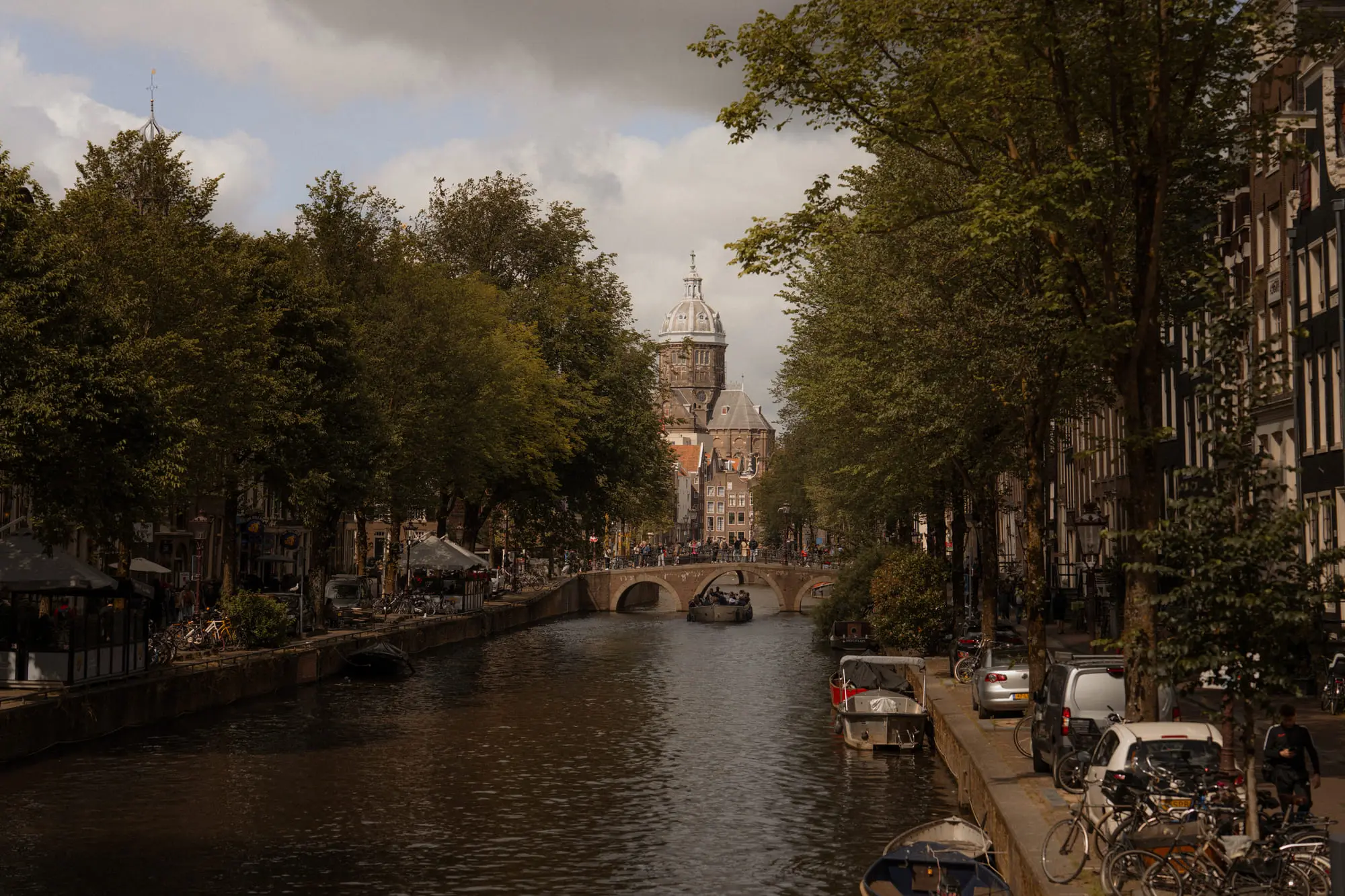 A warm, moody canal view toward St Nicholas Basilica