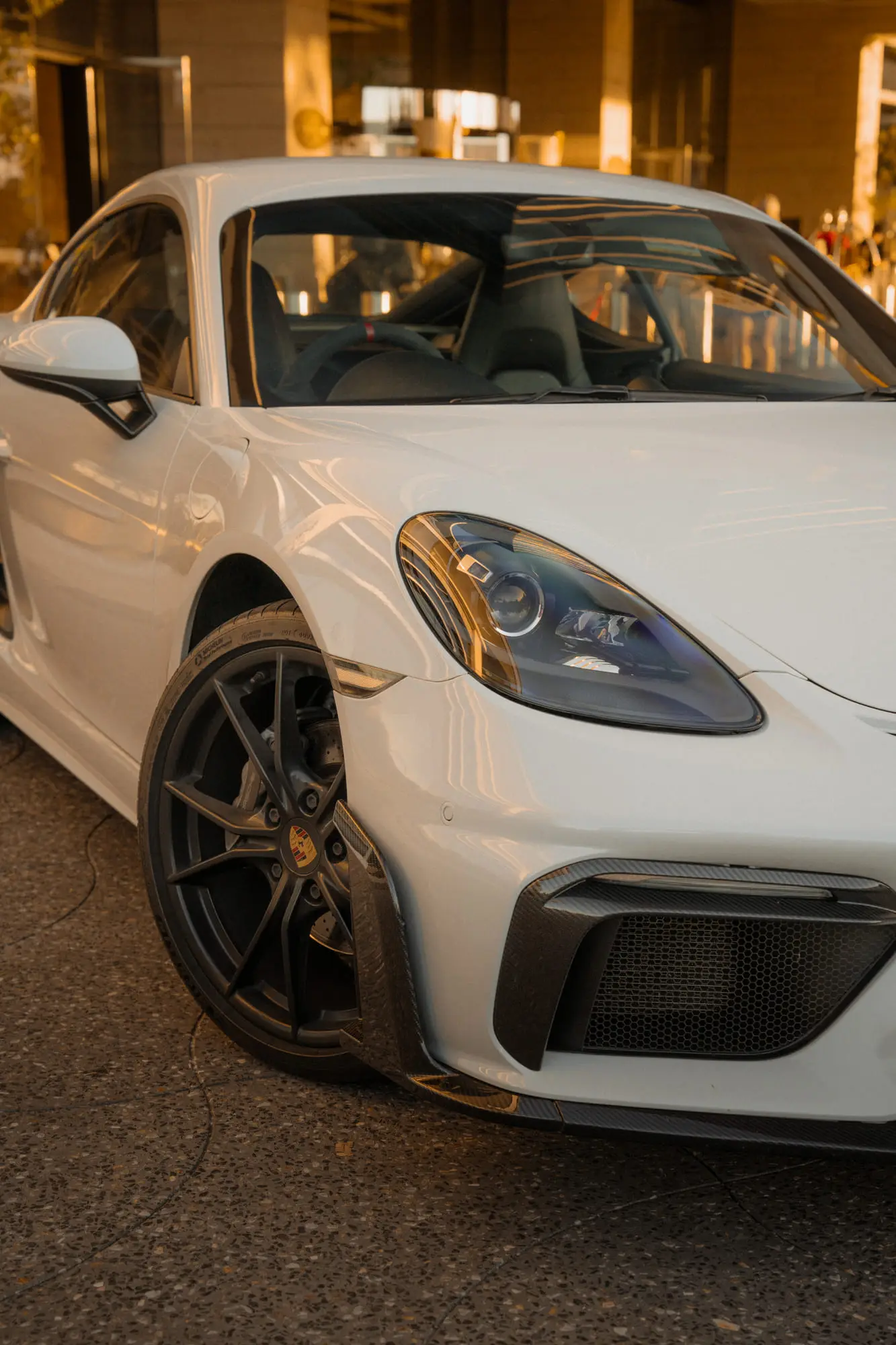 The front three-quarter of the 718 outside a hotel at golden hour