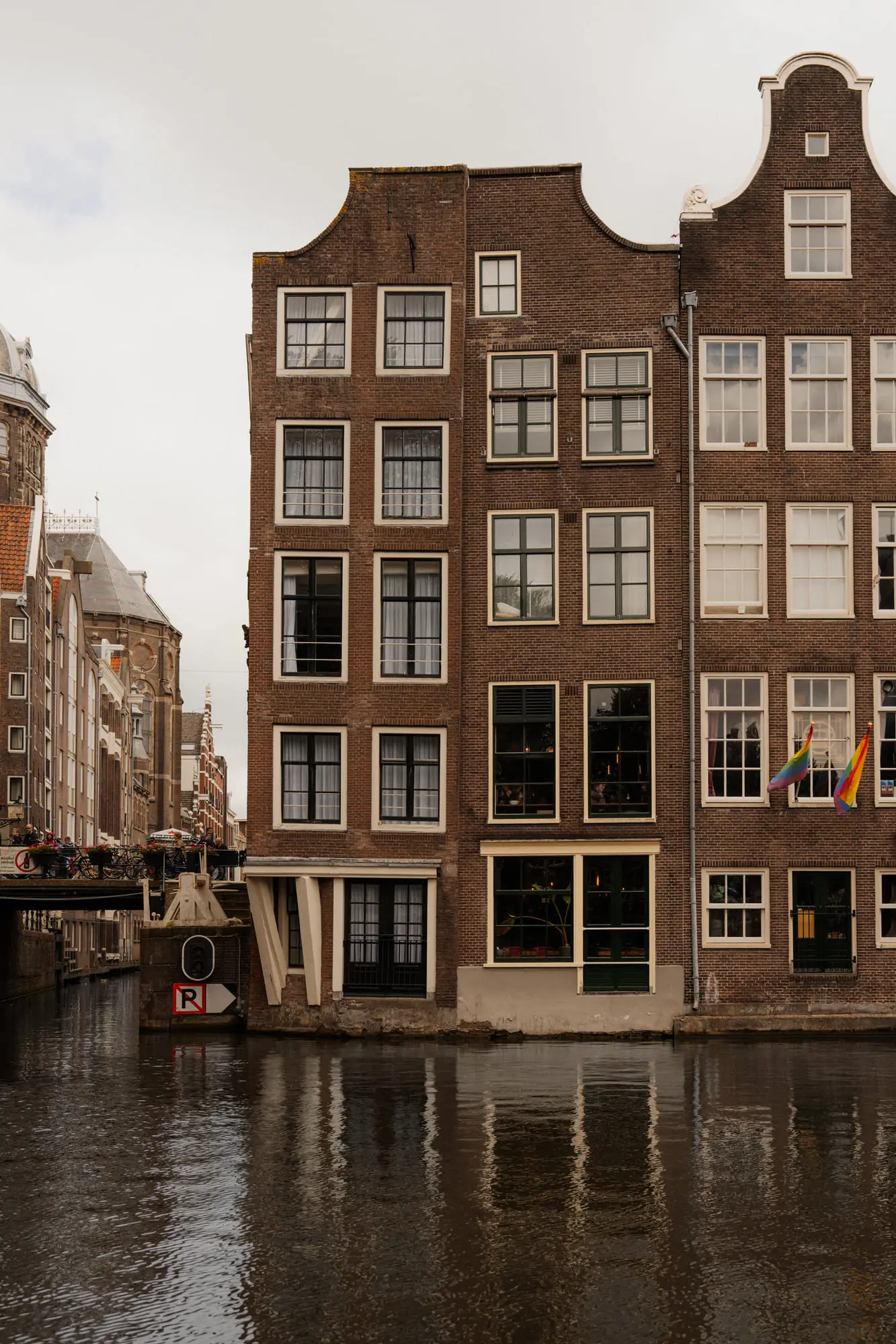 Brick canal-corner houses and a rainbow flag, Amsterdam