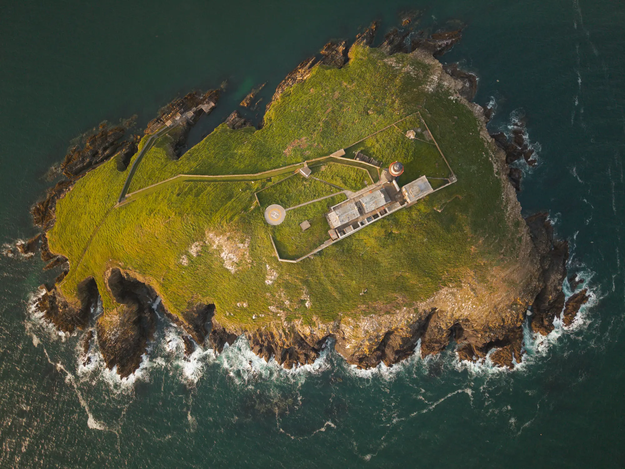A small island with a fort and lighthouse, straight down from above