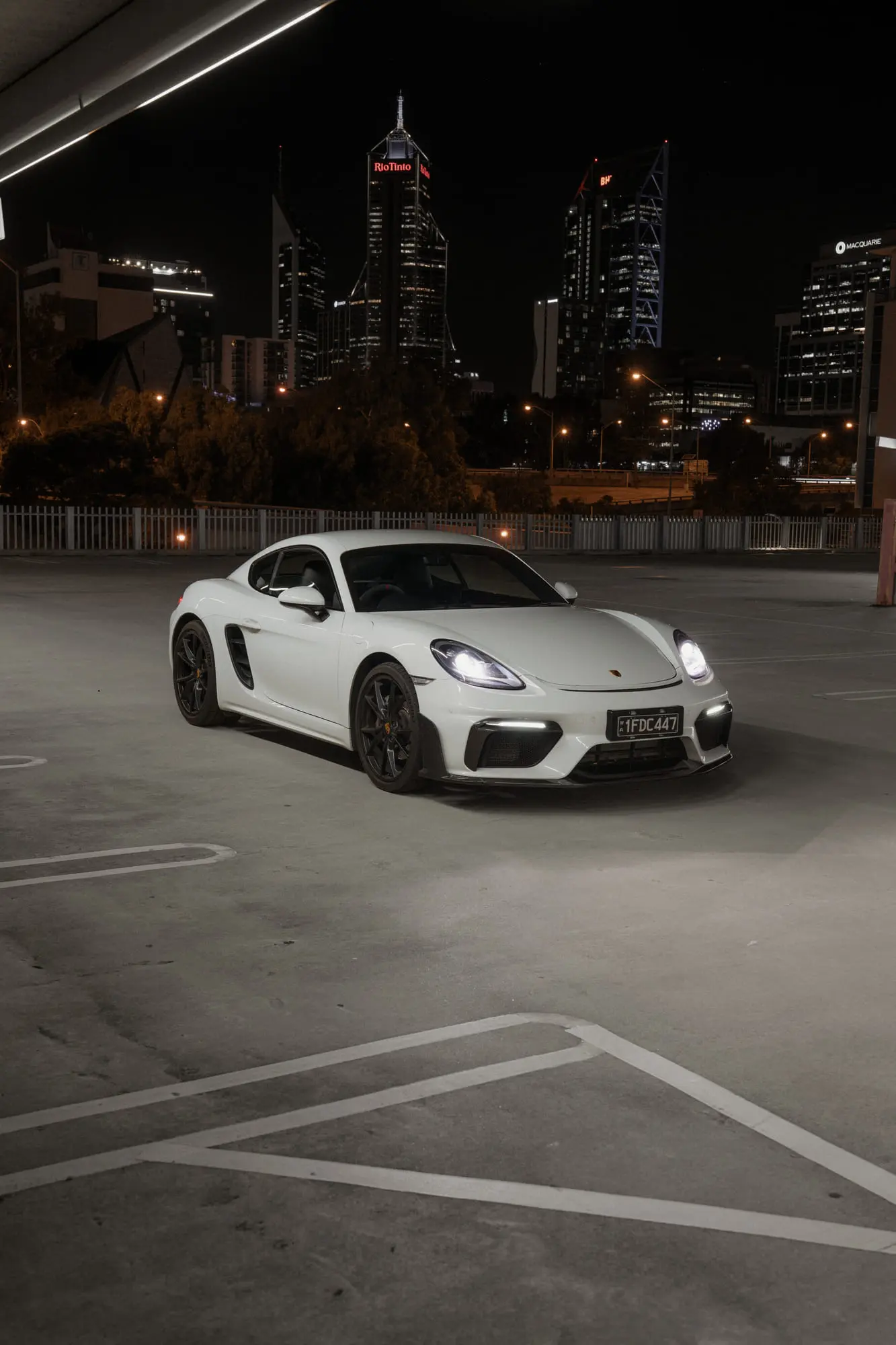 The 718 lit up on a rooftop, city towers behind