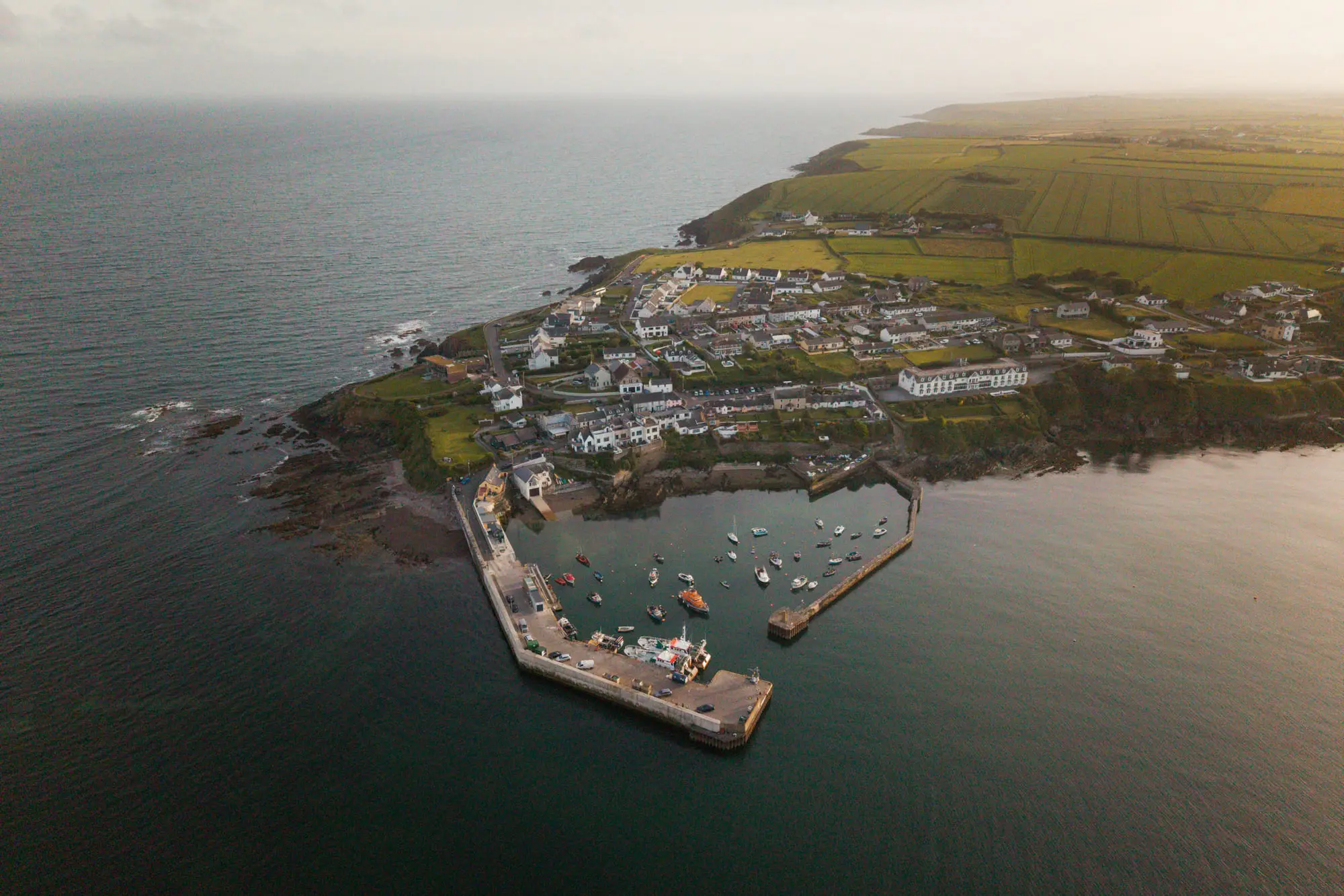 A harbour village on a headland at dusk, from the air