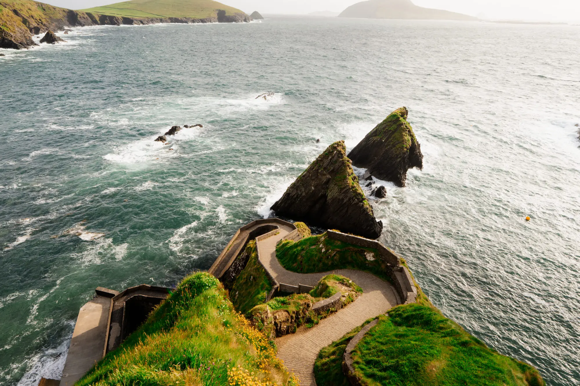 Dunquin Pier and the sea stacks at golden hour, birds in the air