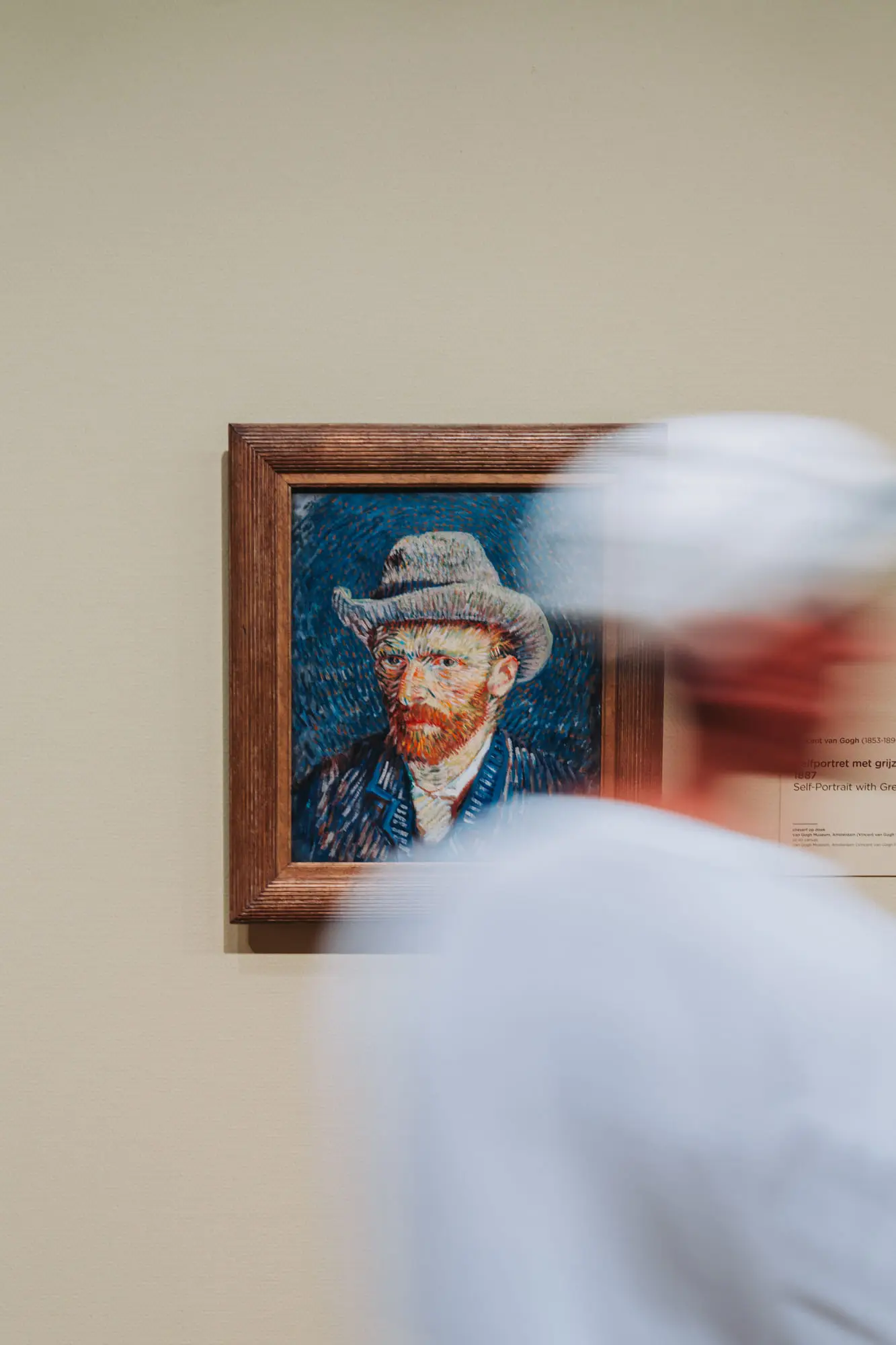 A visitor blurs past Van Gogh's self-portrait at the Van Gogh Museum, Amsterdam