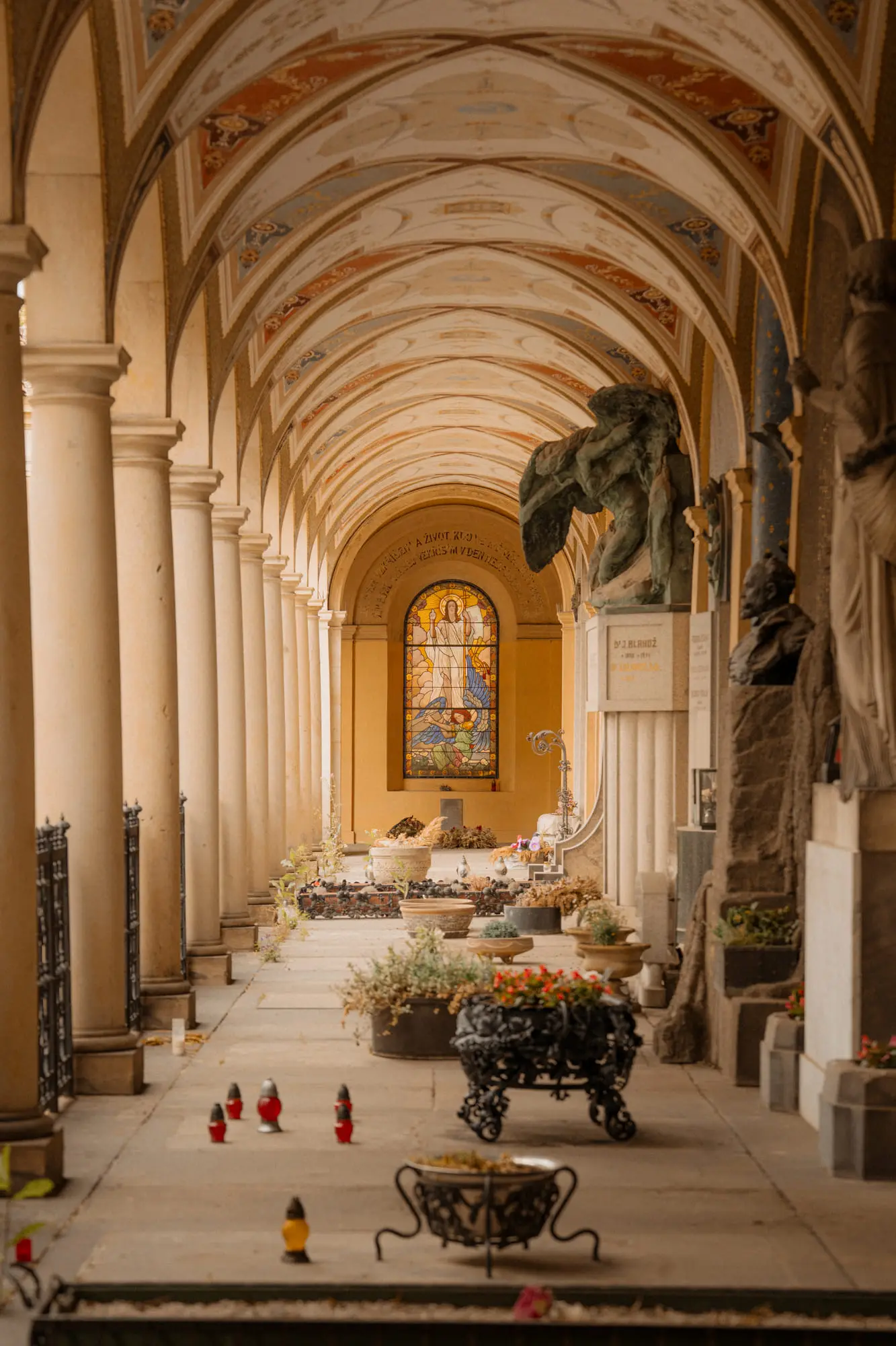 The arcaded cemetery at Vysehrad, graves and candles under a painted ceiling