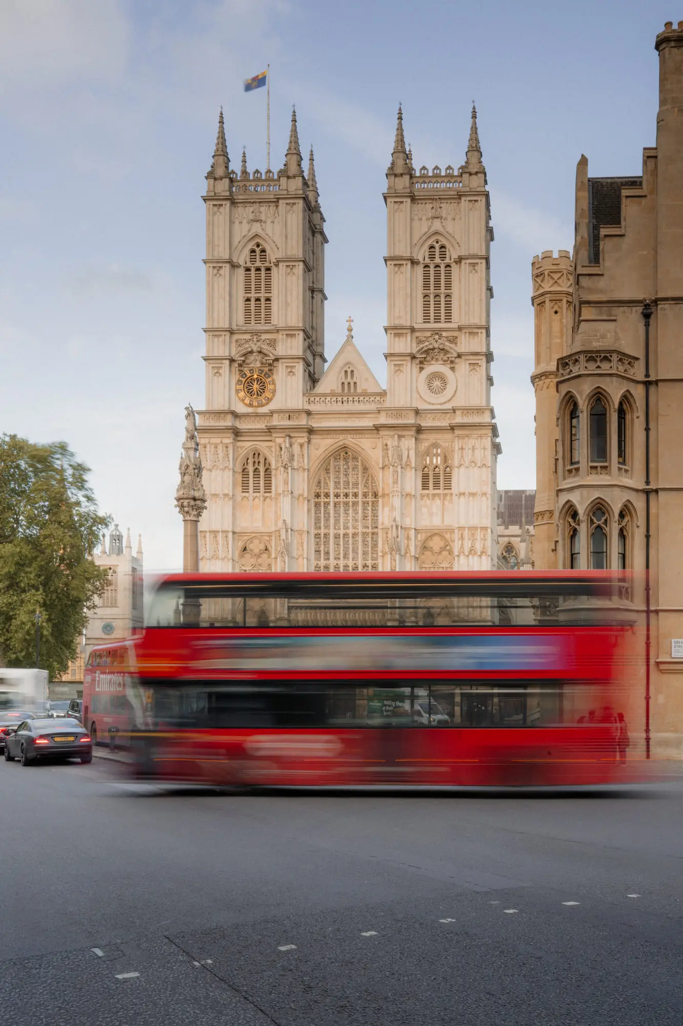 A double-decker blurs past the towers of Westminster Abbey